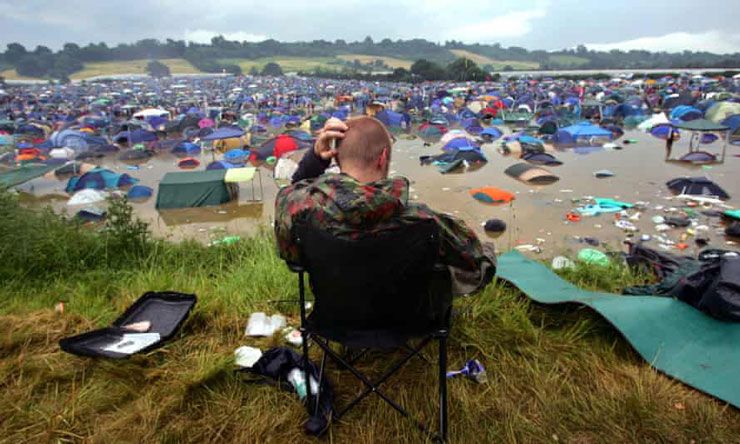 A person sitting in a chair at a beach with a computer
Description automatically generated with low confidence